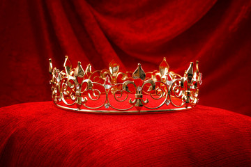 Royalty, monarch coronation or leadership conceptual idea with king gold crown with jewels on red...