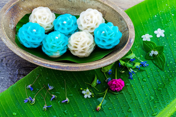 Traditional Thai dessert flower shape stuff with crush soybean and taro (Thai name kanom Chor phaka) in wooden basket on bana leaf.