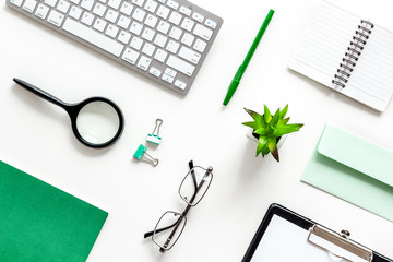 Hipster work desk. Green supplies on white backround flat lay top view top view