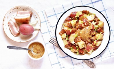 German potato salad with fried bacon and mustard dressing. traditional for oktoberfest festival. top view. copy space.