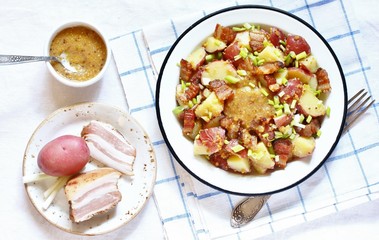 German potato salad with fried bacon and mustard dressing. traditional for oktoberfest festival. top view. copy space.