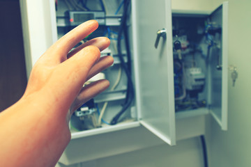 electrician reaches for the electric wires and electric machines dielectric protective glove