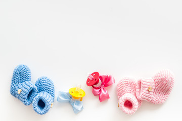 Blue and pink knitted footwear with dummy for baby on white background top view mockup