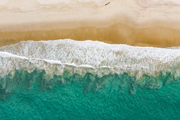 Aerial landscape of a beach at sunset on the east coast with nice sand, beautiful water breaking waves and relaxing vibes on a holiday destination