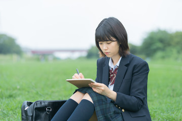 屋外で勉強する女子高生