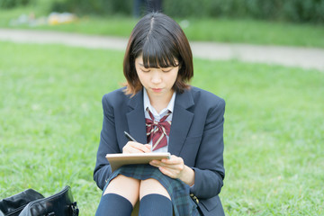 屋外で勉強する女子高生