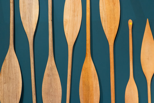 Textura abstracta en madera sobre una pared azul. Remos decorativos colgados sobre una pared.