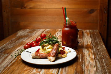 Caesar salad with chicken and bacon on wooden table