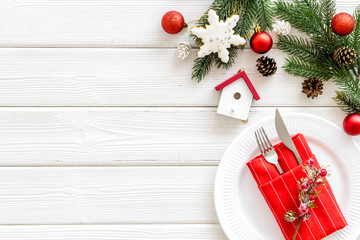 Table setting for new year with pine, decorations, plate and tableware white wooden background top view copyspace