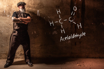 Bearded old man presenting handdrawn chemical formula of acetaldehyde