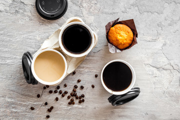 Coffee to-go and muffin gray background top view. Translation of the Russian text on the lid is...