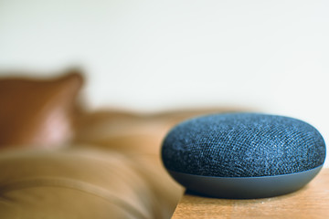 Google home mini on a table next to a sofa