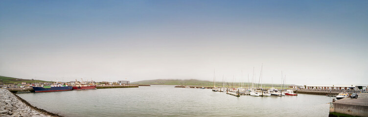 Fototapeta na wymiar Ships in the Dingle harbour on foggy day.