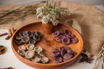 Assortment of sweets without sugar and gluten on a wooden dish. Dessert made from healthy natural ingredients. Beautiful composition of healthy diet candies and flowers