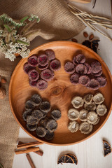 Assortment of sweets without sugar and gluten on a wooden dish. Dessert made from healthy natural ingredients. Beautiful composition of healthy diet candies and flowers