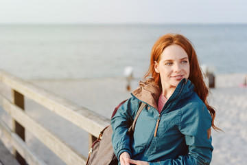 Happy relaxed young woman watching on a beach