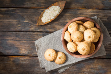 Sesame biscuit in a wooden bowl on a wooden posthole. Rustic style