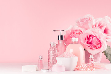 Luxury bathroom interior in romantic style - soft  roses, cosmetic products for skin and body care, accessories, pearls on pastel pink, white background, closeup.