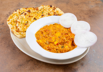 Indian Vegetarian Cuisine Special Sweet And Spicy Paneer Pasanda or Stuffed Paneer Curry, Delicacy Consisting of Stuffed Paneer with Rich Creamy Gravy Served With Garlic Naan on Vintage Background