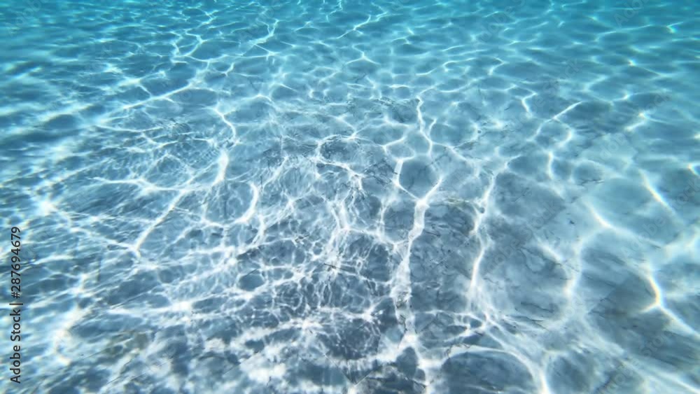 Poster sunlight makes patterns on the bottom of a pool as it passes through the clear blue water. bright tr