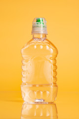 Plastic bottle of mineral water on a bright yellow background