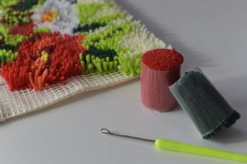 A rug in latch hoook technique with thread chunks and hook