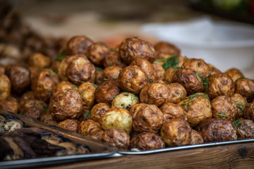 Ukrainian country fair cooking roasted potatoes cooked outdoors cookout vegetable meals fresh organic, healthy snack cooked on grill flame. Street fast food.
