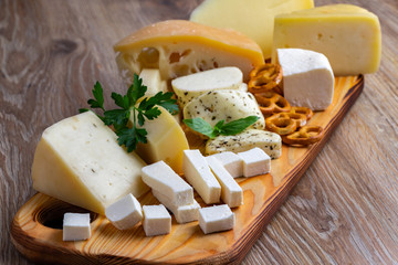 Different types of cheese on a wooden cutting board
