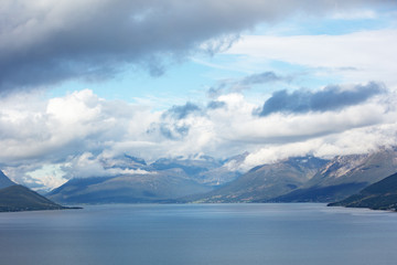Island on the horizon. Rocks in the sea. Beautiful rocky sea landscape with dramatic cloudy sky. Wild nature of Norway
