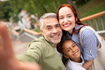 Parents and daughter smiling broadly while posing for photo