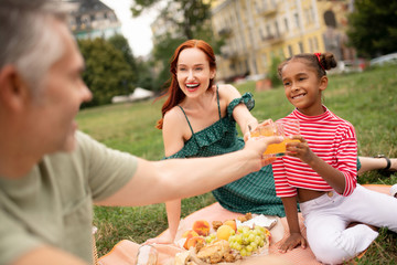 Adopted girl feeling amazing enjoying weekend picnic with parents
