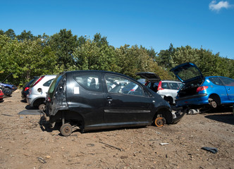 Fototapeta na wymiar Small black scrap car missing whells