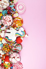 candies with jelly and sugar. colorful array of different childs sweets and treats on pink