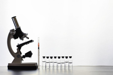 Research laboratory. Test tubes and microscope on the table on a white background.