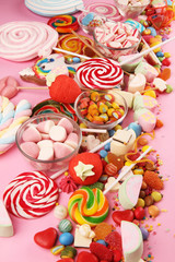 Fototapeta na wymiar candies with jelly and sugar. colorful array of different childs sweets and treats on pink