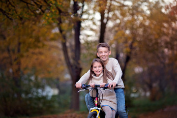 Closeup autumn portrait of cute brother with sister have fun together