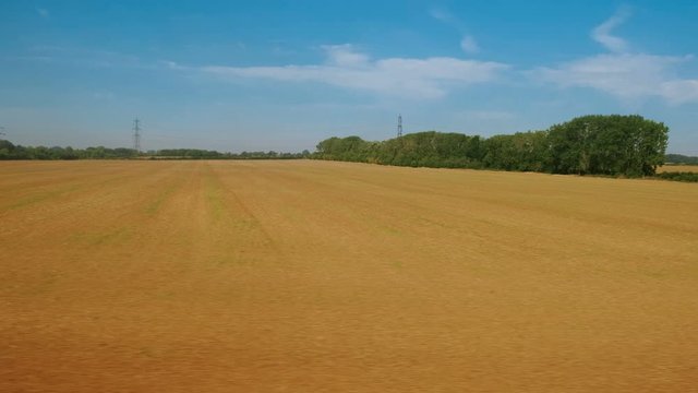 Passenger view of amazing croplands and rolling hills in the Cotswolds in England, UK, an Area of Outstanding Natural Beauty with 787 square miles, the second largest protected landscape in England