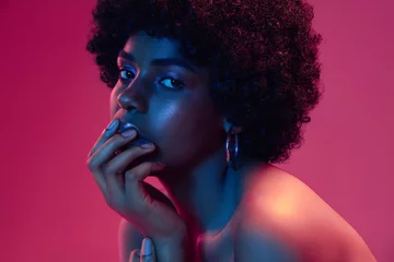 Der Sonnenuntergang des Sommers. Porträt des weiblichen Modemodells im Neonlicht auf Steigungshintergrund. Schöne afrikanische Frau mit trendigem Make-up und gepflegter Haut. Lebendiger Stil, Schönheit, Kosmetikkonzept. © master1305
