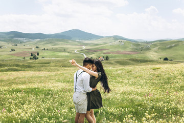 Woman with man cuddling in the field. Intimate relationships and love.