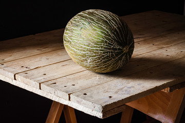 MELON ON WOODEN TABLE. RUSTIC FOOD PHOTOGRAPHY