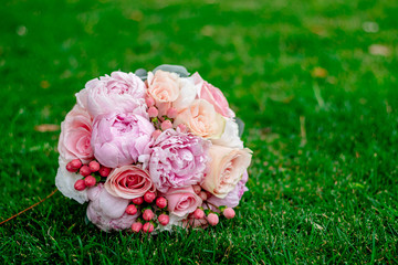 nice and beautiful wedding bouquet of flowers on green grass