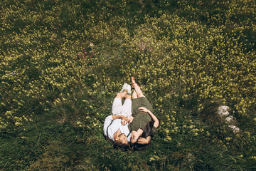 A young couple lies and hugs on the grass and dreams