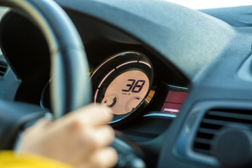Modern car interior with driver hand on steering wheel. Safe driving concept.