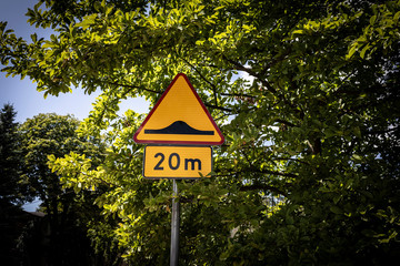 Warning road sign. Speed bump at a distance of 20 m