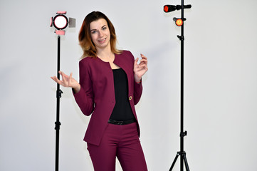 Portrait of a pretty young brown-haired business woman on a white background in a dark business...