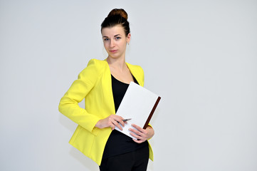 Portrait of a pretty young brown-haired secretary woman on a white background in a yellow jacket with gathered hair. He stands in different poses, talking, different emotions.