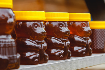 Many jars with fresh organic honey on farm market. Colorful honey on a market in Altai.