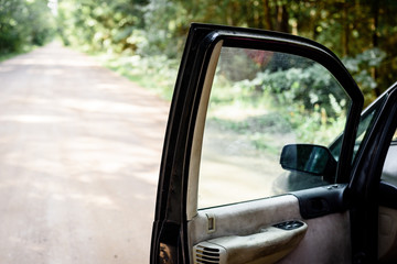 A black vehicle with an open door in side of the road.