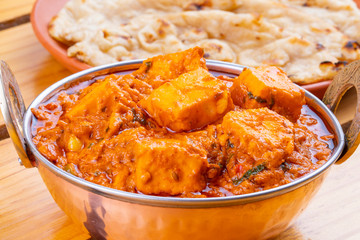 Indian Delicious Spicy Vegetarian Cuisine Paneer Toofani Also Know as Paneer Tufani, Toofani Paneer Masala or Dhaba Style Paneer Masala Served with Tandoori Roti on Wooden Yellow Background
