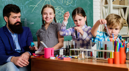 Fototapeta premium School education. School club. Explaining chemistry to kid. Fascinating chemical reaction. Teacher and pupils with test tubes in classroom. Interesting school classes. School chemistry experiment